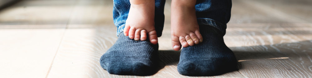 Small child standing on father's feet